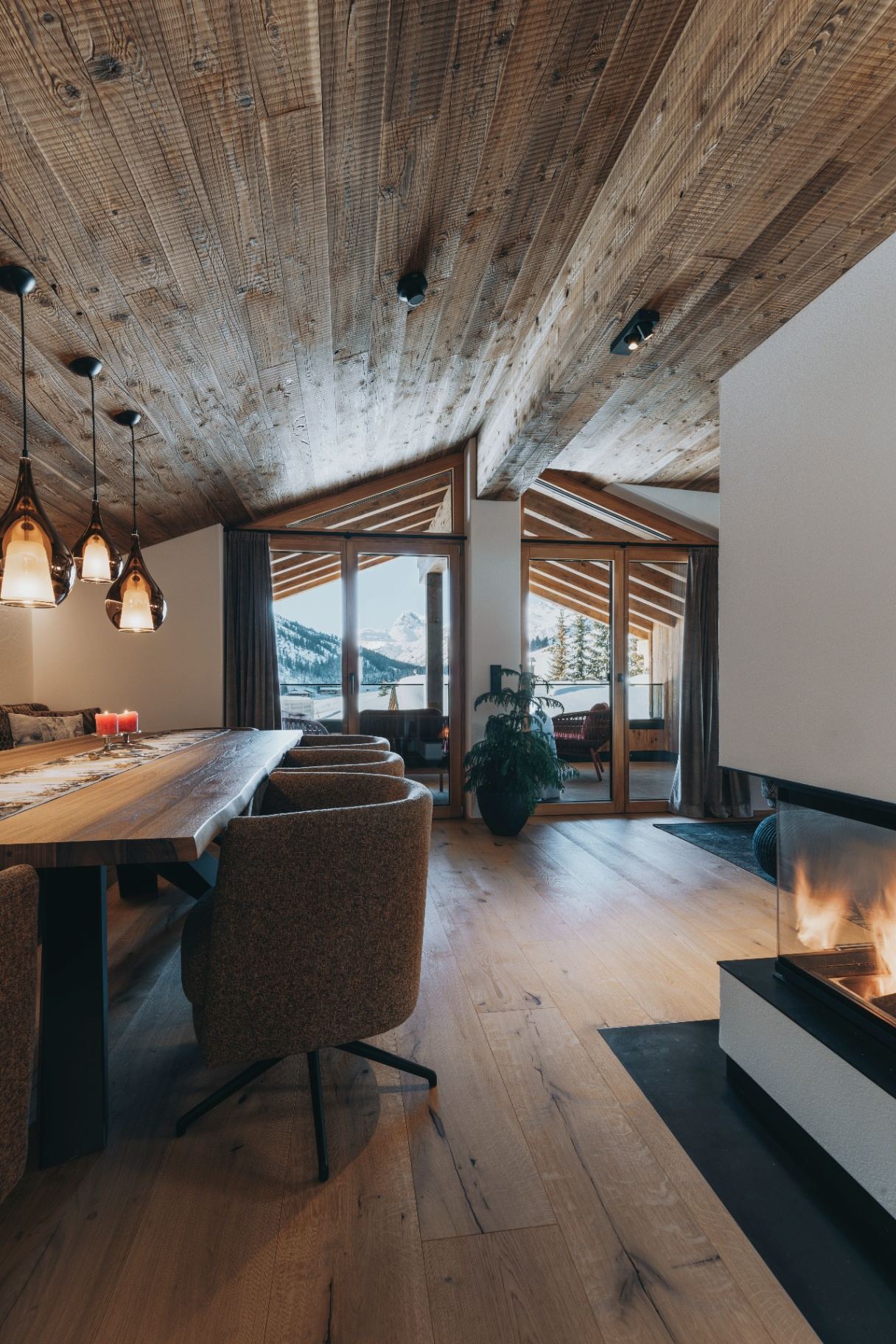 Großzügiger Wohnbereich mit dreiseitigem Kamin und Panoramafenstern in Room N°4, Balma Boutique Hotel Lech