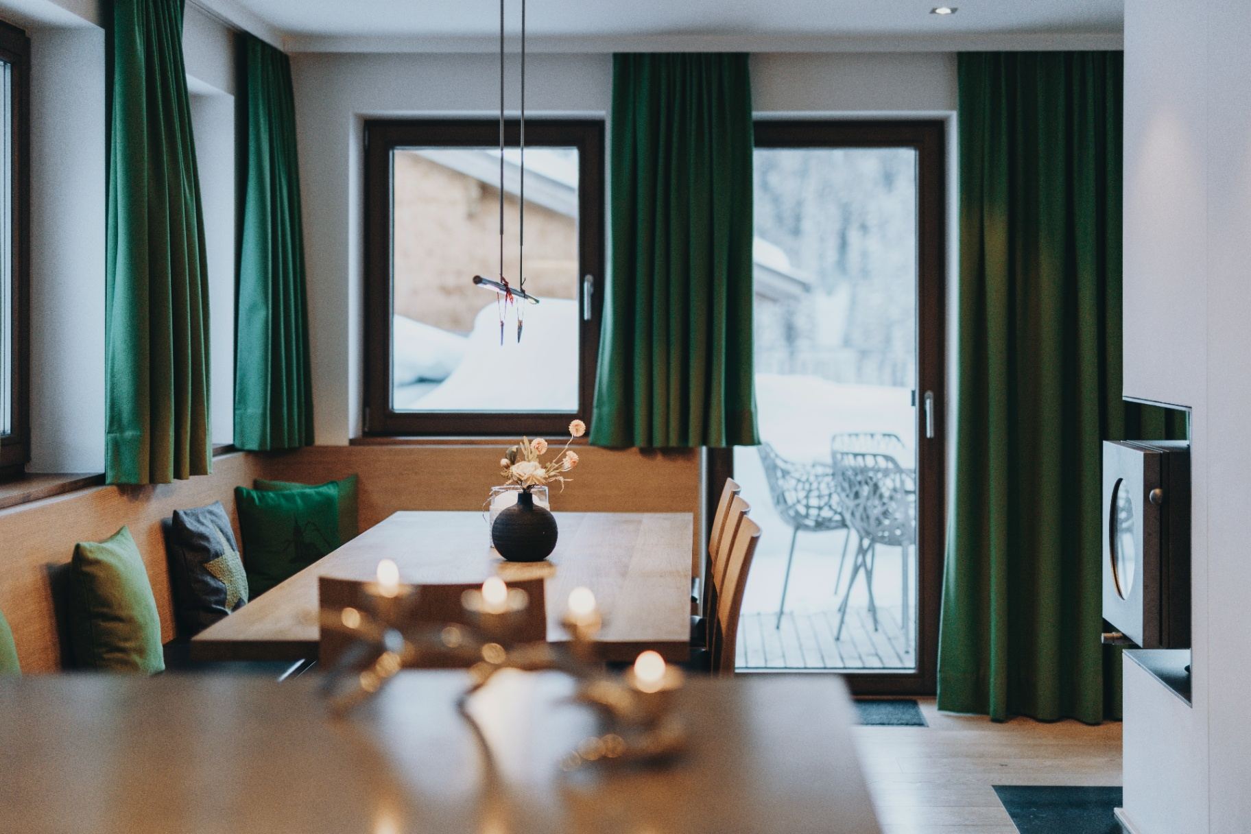 Essbereich mit Winterpanorama und grünen Samtvorhängen